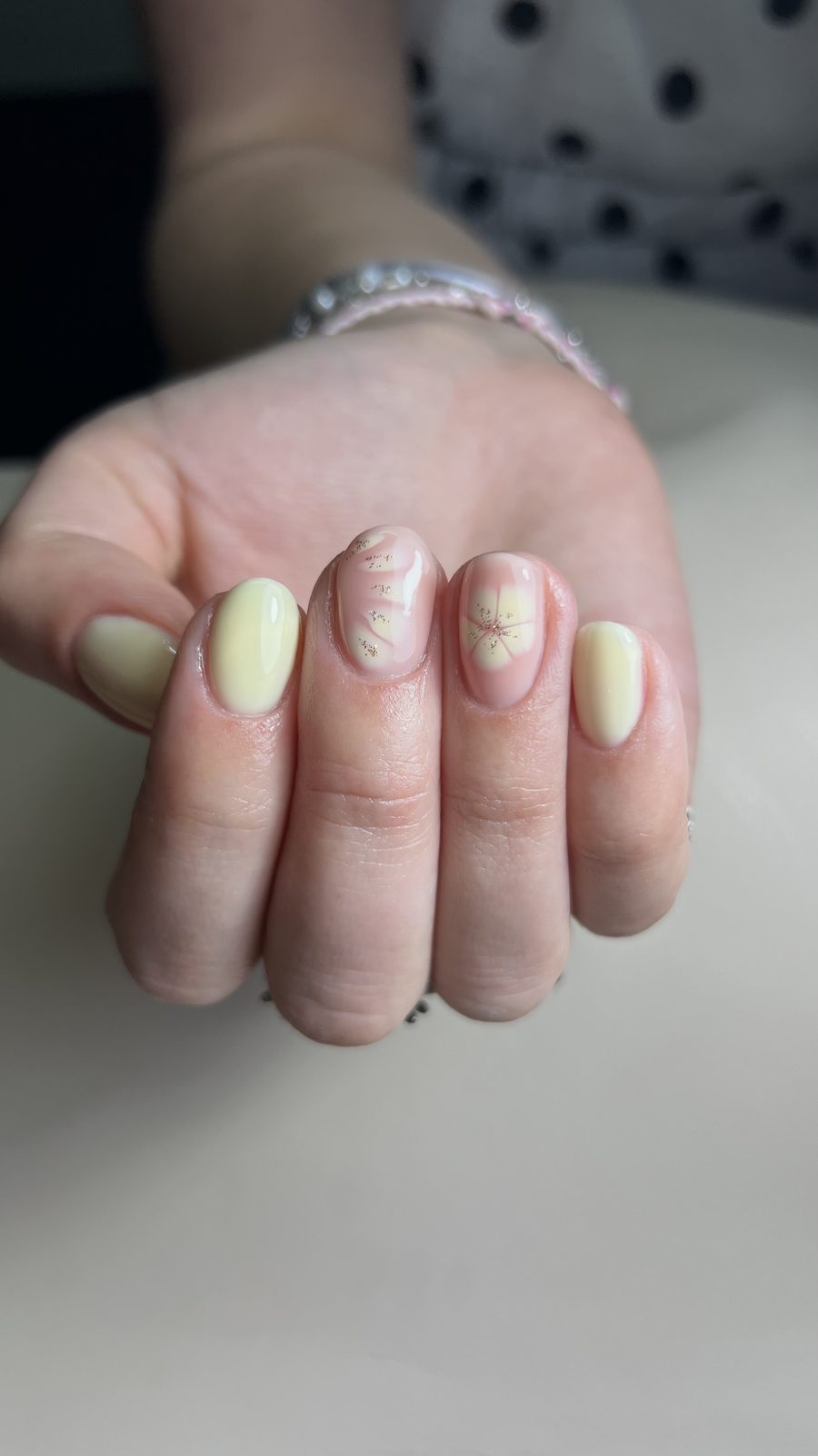 Pastelgele nagels met handgeschilderde bloemetjes